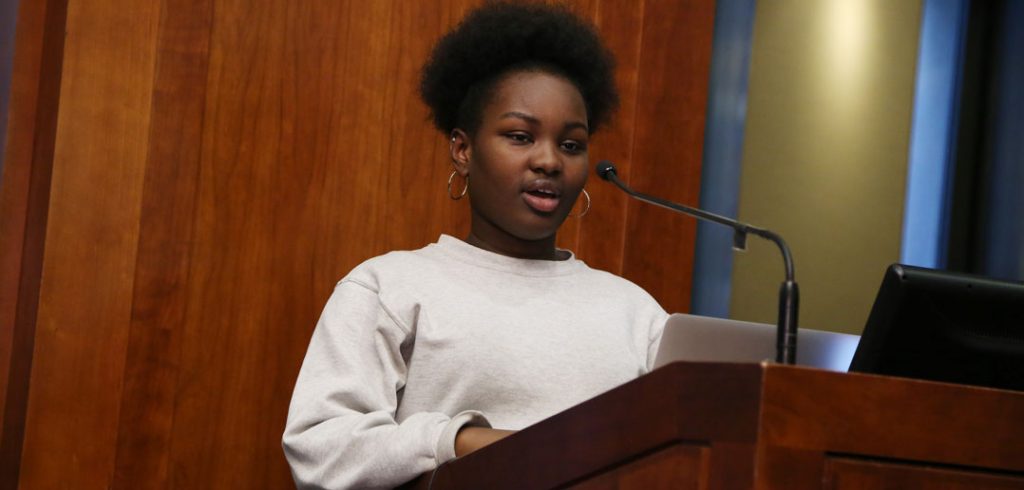 High schooler Laurynn Laurore reads poetry at the podium at Poets Out Loud reading on April 11