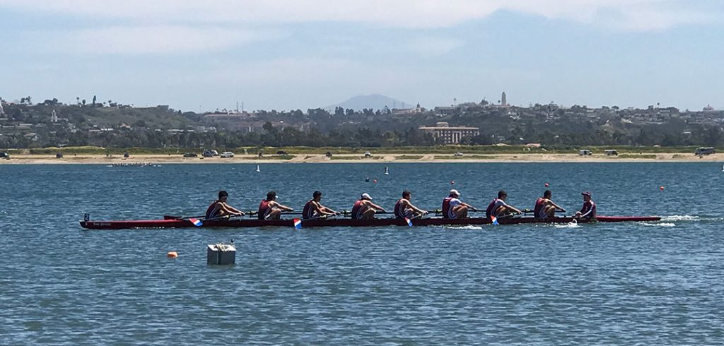 The men's crew team rowing on the water.