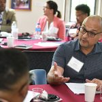 Rafael Zapata speaks with a woman at a table