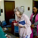 Anthony Abraham Jack speaks wit h a woman who is standing while he is sitting.