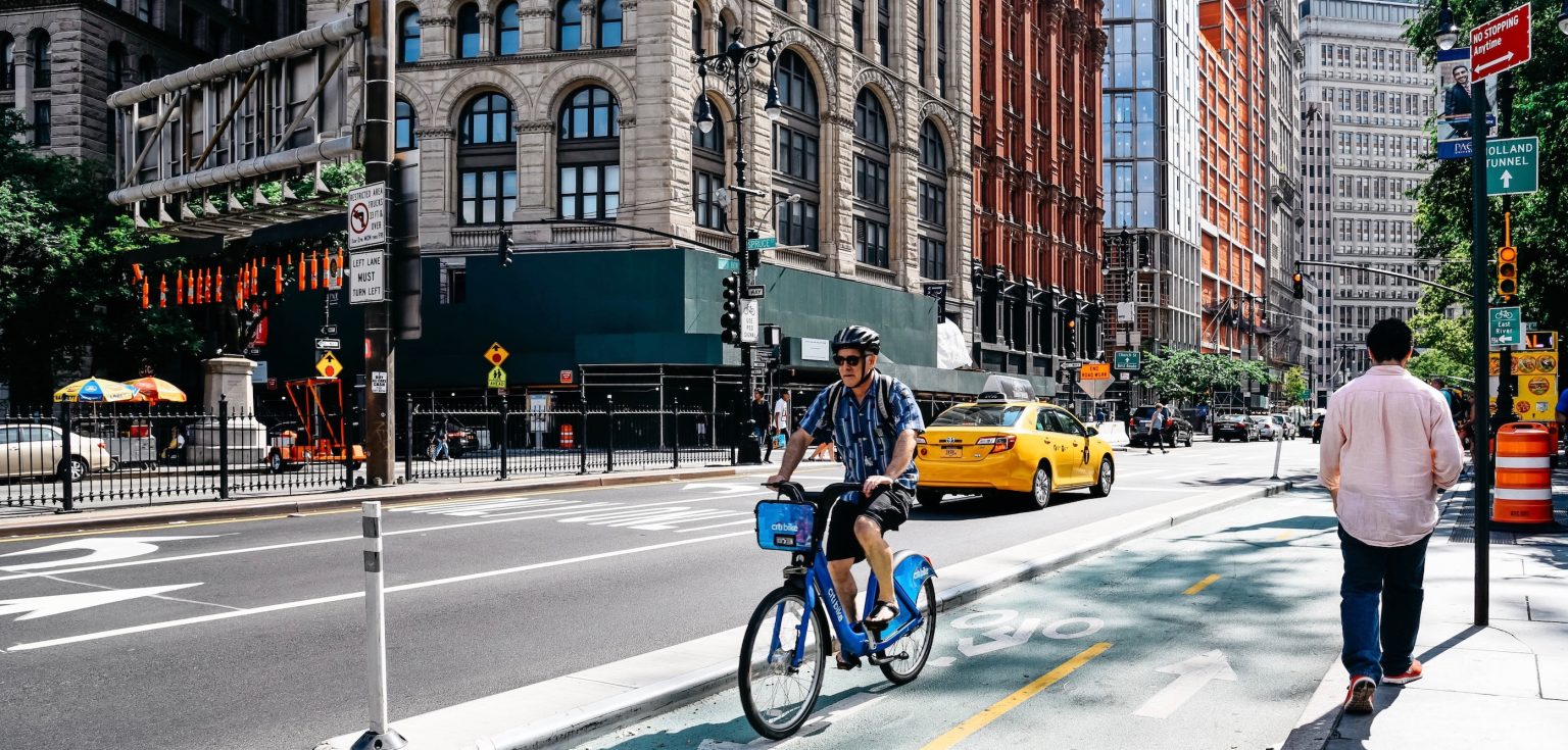 A man riding a bike against a city background