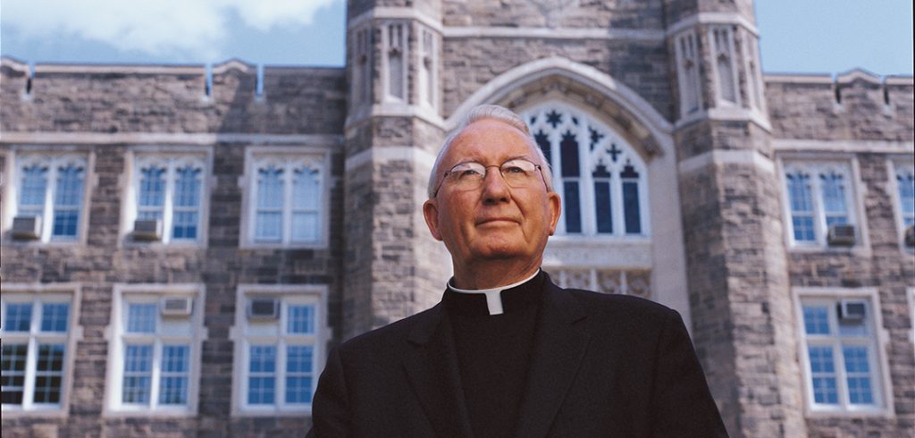 Father Joseph A. O'Hare, S.J. in front of Keating Hall.