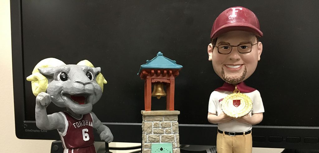 Bobbleheads of a man, a Ram, and a miniature of the victory bell
