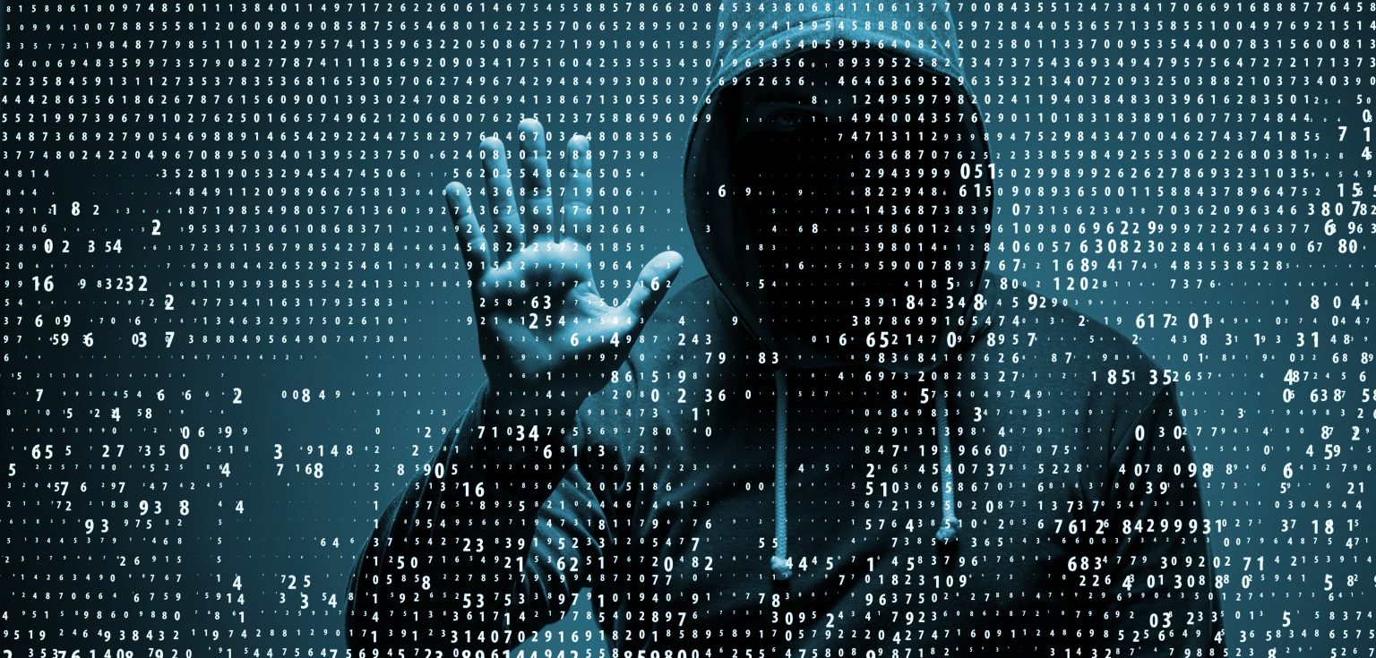 A man wearing a hood with his face hidden presses his palm against a transparent screen, while numbers swirl around him.