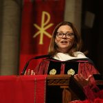 President Tetlow in academic robes speaking on altar