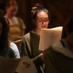 Young woman singing in the pews