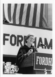Mary Robinson at podium with Fordham banner behind her. 