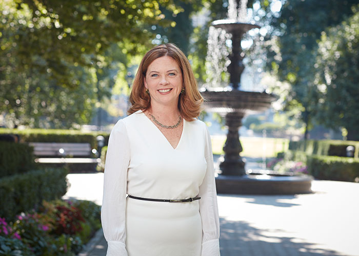 Fordham University President Tania Tetlow stands in front of Cunniffe Fountain on the Rose Hill campus