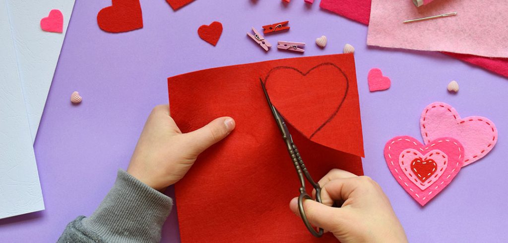 Hands doing Valentines Day crafts