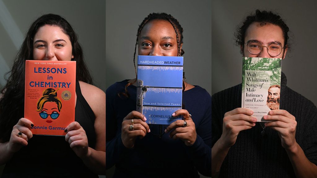Three Fordham students hold up a copy of a book they're reading