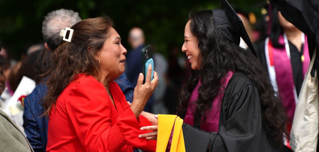 A mom and daughter embrace after graduation