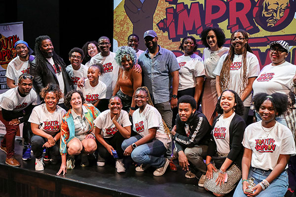 Marjuan Canady posing with a group at a youth improv event sponsored by the Canady Foundation for the Arts.