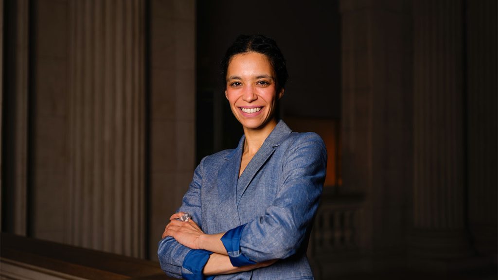 Fabiana Weinberg smiling with arms crossed on the second-floor atrium of the Metropolitan Museum of Art.