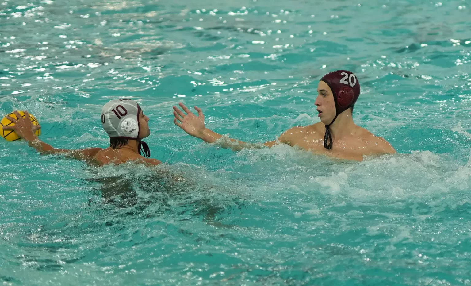 Andras Toth in pool playing water polo with opponent.