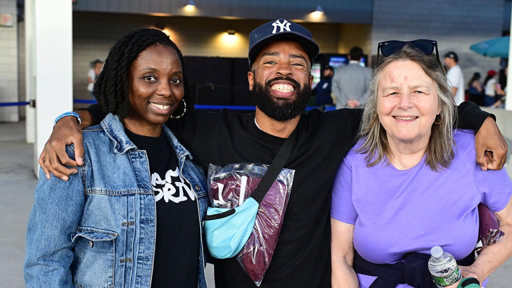 Three people smile for a picture