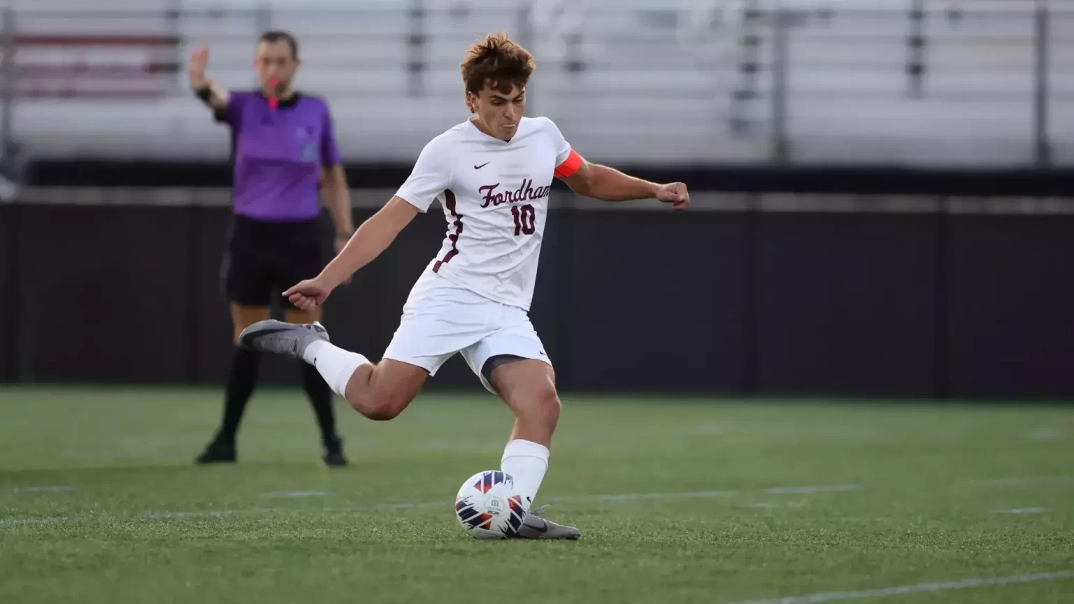 Daniel D'Ippolito kicking a soccer ball, in soccer uniform.