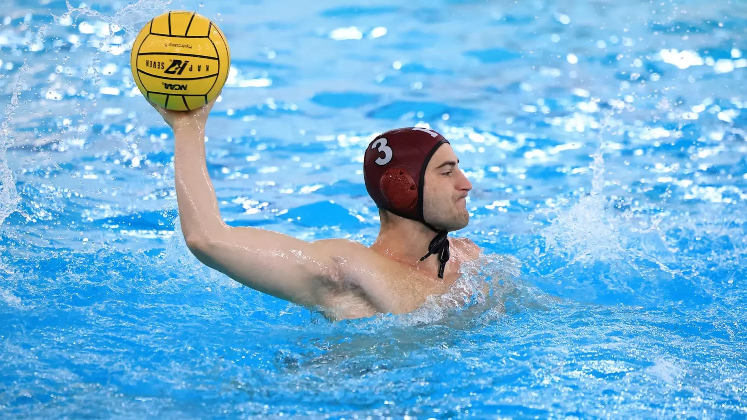 Man playing water polo in pool.