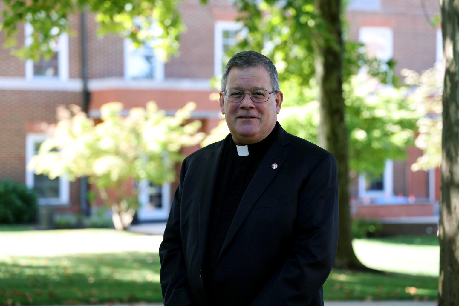 Father Philip Judge, executive director of Campus Ministry at Fordham, stands outside on campus.