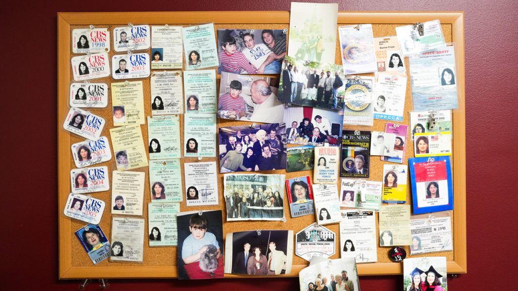 A bulletin board pinned with press passes and photos