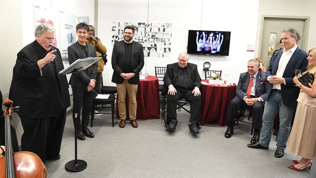 Father DeCola giving Father Grimes a musical tribute