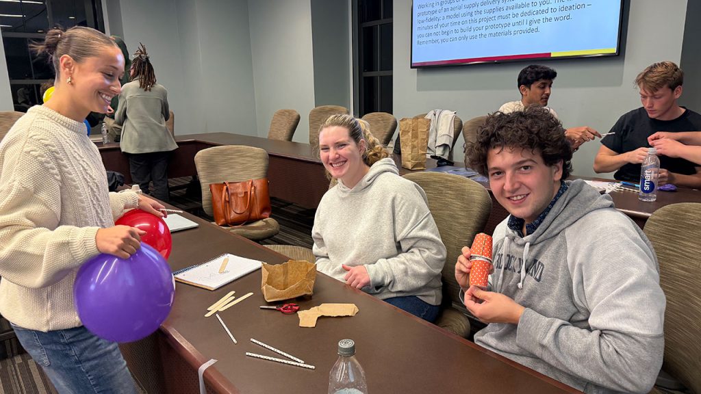 Three students working at a table together.