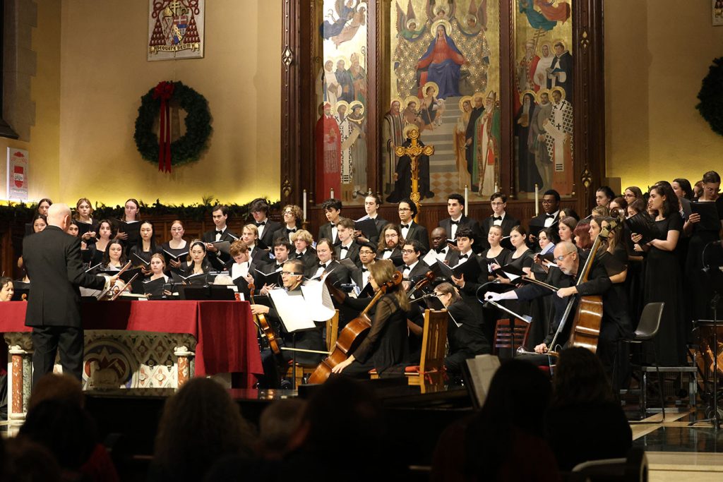 Members of the combined Fordham choirs and the Bronx Arts Ensemble play and sing on the alter of the University Church.