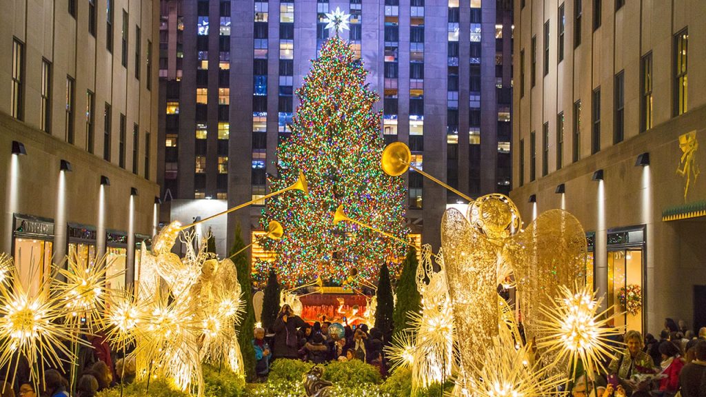 Rockefeller Christmas Tree with angel sculptures in forefront.