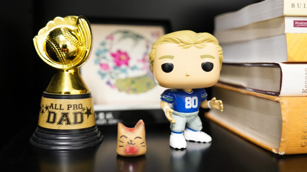 A Funko Pop and other tchotchkes on a bookshelf