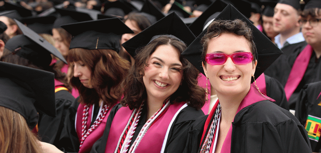 A group of smiling people in cap and gown at Fordham's commencement ceremony