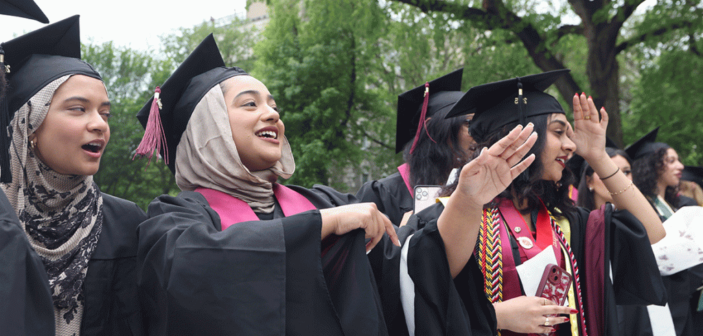 A group of smiling graduates at Fordham's commencement ceremony