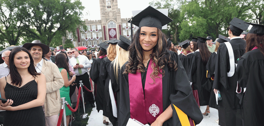 A graduate smiles at Fordham's commencement ceremony