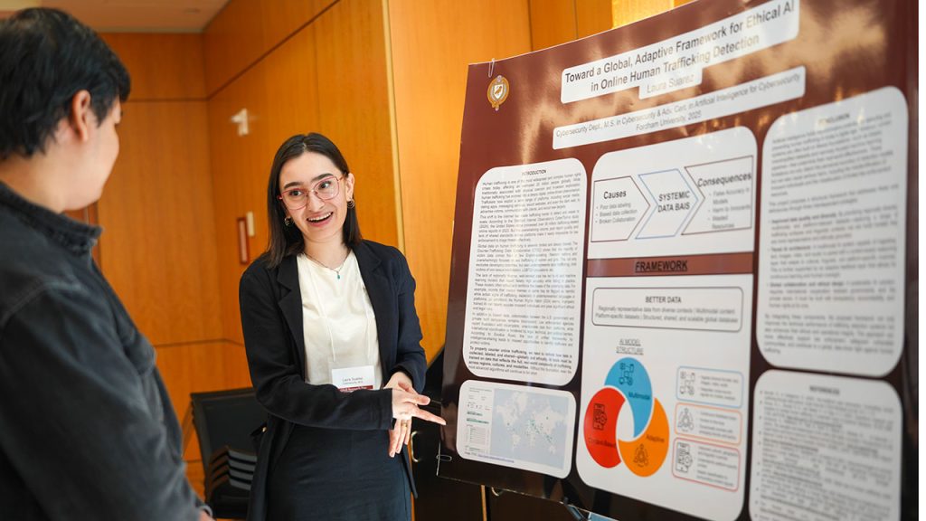A woman wearing glasses shows off research on a white board.