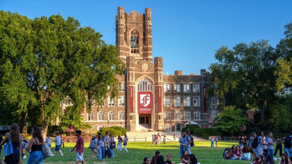 A photo of Fordham's Keating Hall with banners featuring the new logo
