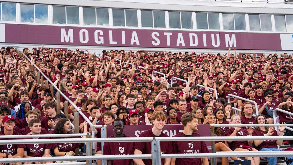 A photo of a large group of students taking a class photo for Fordham's class of 2029 at Moglia Stadium.