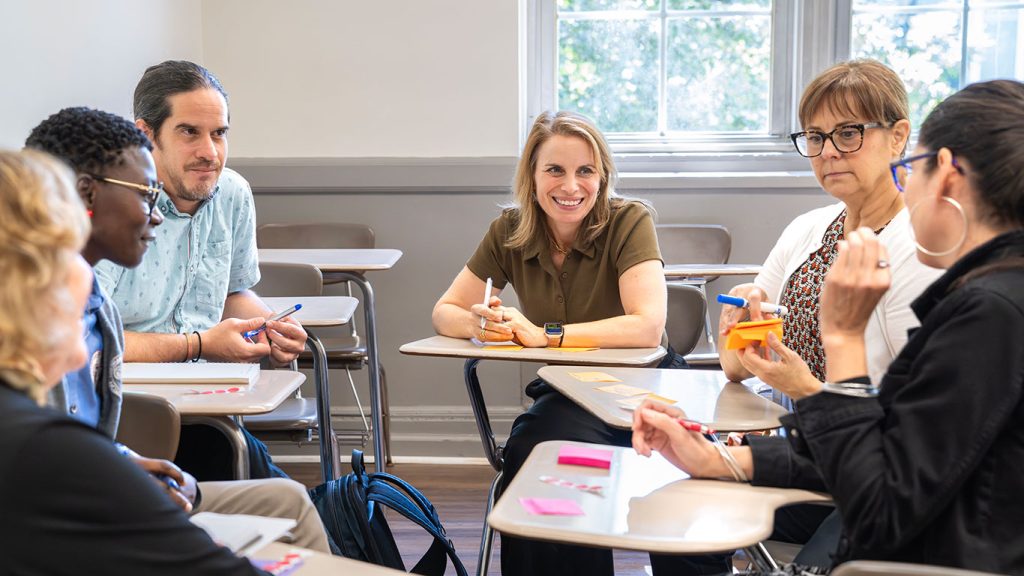 People seated around a table smiling and exchaning ideas