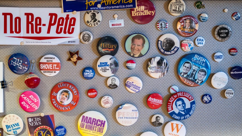 An assortment of buttons pinned to a bulletin board