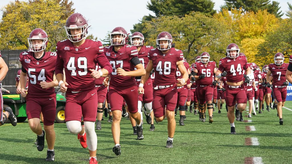 Football members run onto the field