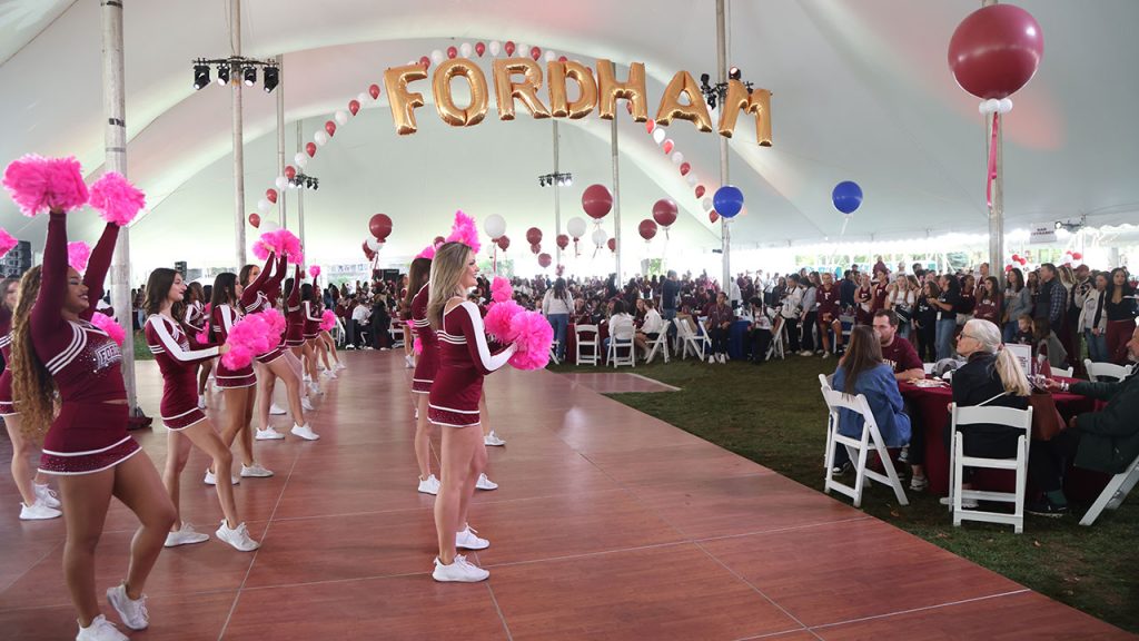 Fordham cheerleaders perform in a tent