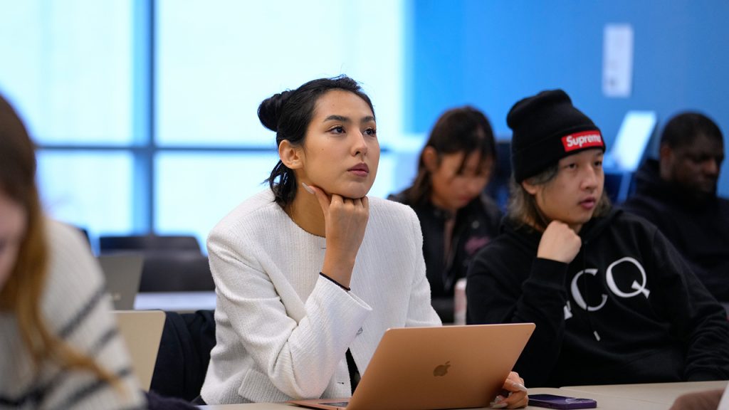 Fordham Offers Certificate Focused on AI Ethics A woman with laptop in front of her looks up