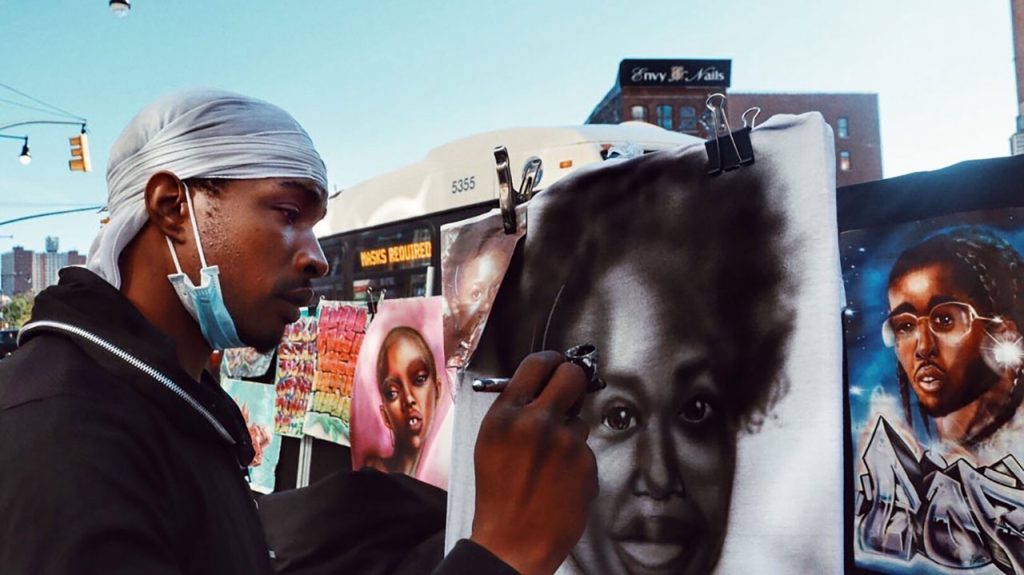Man creating airbrush art outside Bronx