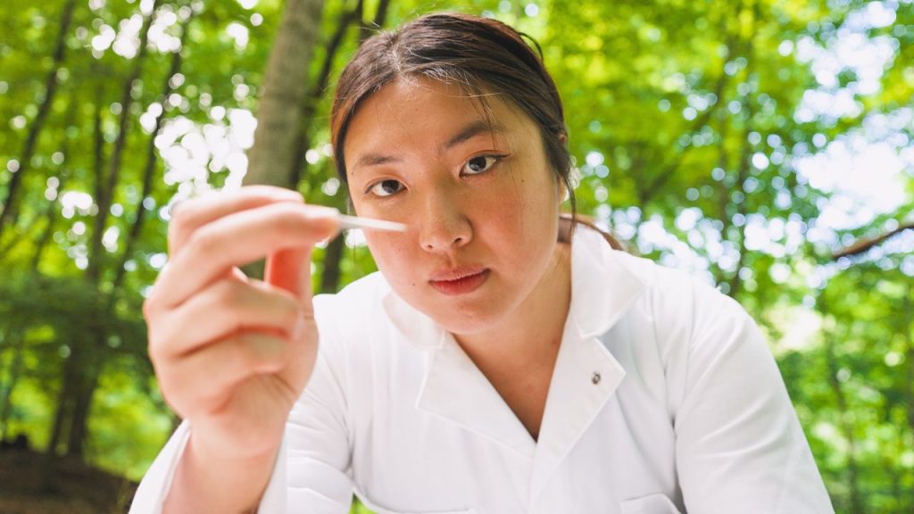 Fordham Named to ‘Green Colleges’ List by The Princeton Review A woman in a white lab coat looks at a sample in a dropper, representing Fordham's place on the Princeton Review's Top Green Colleges List for 2026.