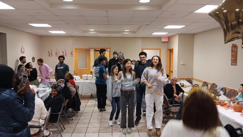 Students dance at a senior hom with seniors watching