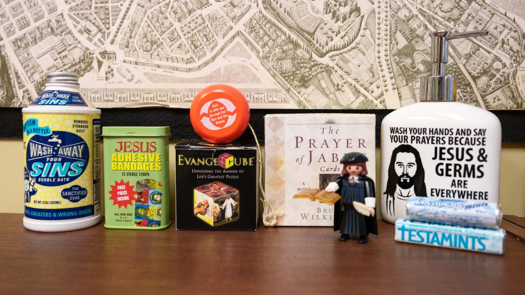 A collection of religious kitsch on a bookshelf