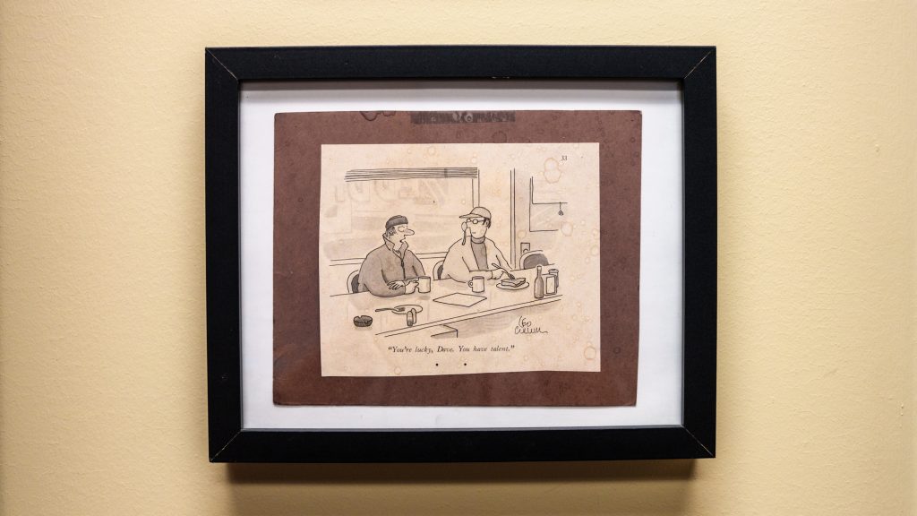 A framed cartoon on a wall