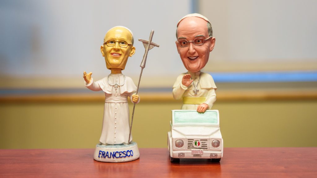Two bobbleheads of Pope Francis on a desk