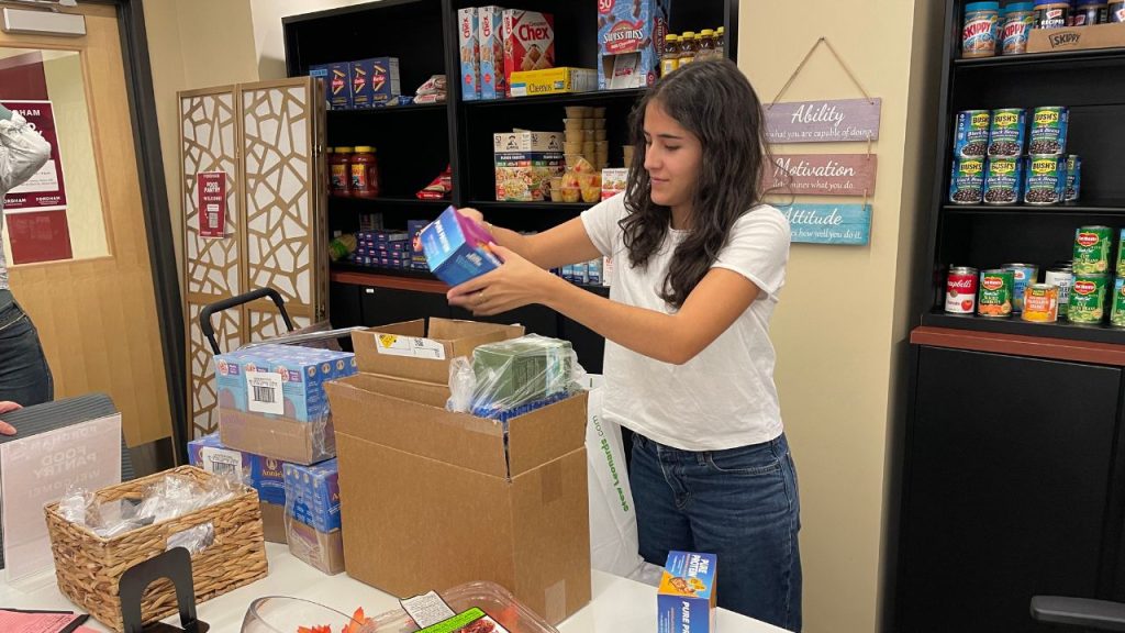 Valeria Ramos Prado helps stock a Fordham food pantry during the government shutdown