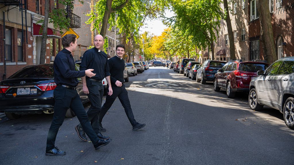 Jesuit scholastics walk outside of Ciszek Hall