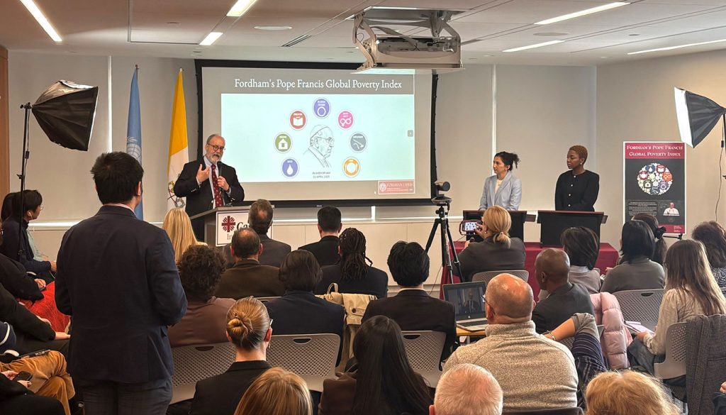 A man standing in front of a podium speaking to reporters.