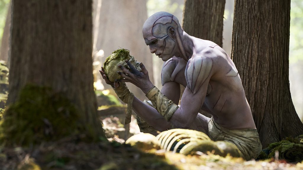 Frankenstein's creature, portrayed by Jacob Elordi, shown clutching a skull in the woods
