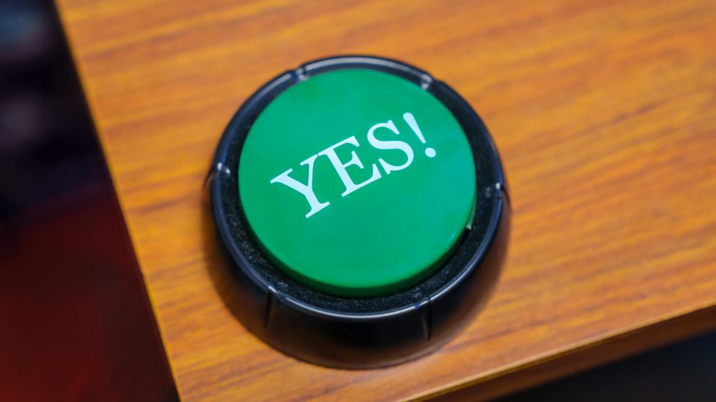 A green button that says "YES!" on a table